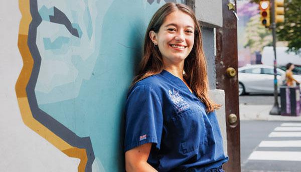 杰西卡·罗斯16岁穿着蓝色手术服靠在墙上