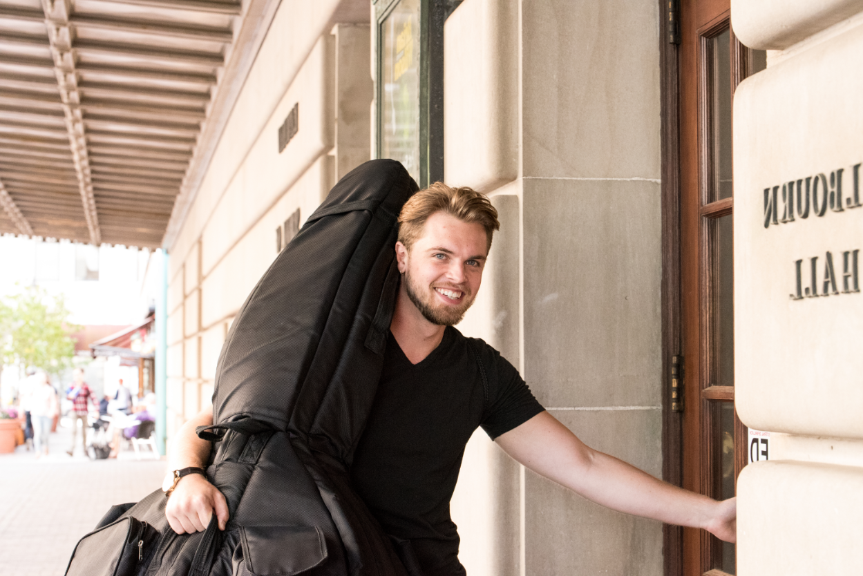 Music student with instrument entering Eastman School of Music
